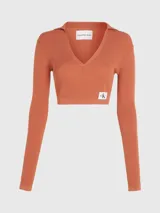 Sweater cropped de Calvin Klein, confeccionado en punto de lyocell con textura acanalada. Presenta cuello tipo polo con escote en pico, mangas largas y una insignia con el monograma de la marca en el bajo.