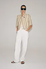 Blazer cropped ZW Collection confeccionada en mezcla de algodón, con diseño a rayas verticales en tonos azul y rojo sobre base beige. Presenta cuello redondo, manga corta, forro interior a tono y cierre frontal con un botón.