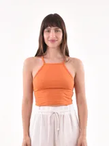 Musculosa color naranja, de corte crop top y escote halter con tirantes finos.