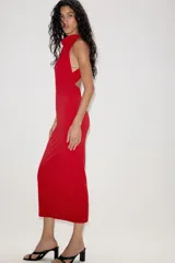 Vestido largo de corte fluido con cuello halter y espalda descubierta. Presenta un detalle de drapeado lateral y bajo recto.