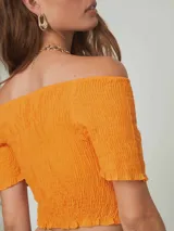 Top naranja con textura arrugada, escote off-shoulder y mangas cortas con volados.