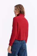Buzo de tejido de punto con trama marcada, color rojo, diseño de cuello alto con cierre frontal y mangas largas.