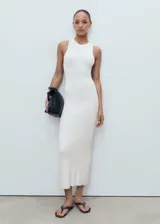 Vestido largo de punto, color blanco, con cuello halter y diseño entallado al cuerpo.