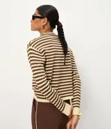 Sweater de punto de manga larga, con rayas horizontales en azul marino y blanco. Presenta cuello redondo ligeramente elevado y puños y ruedo en color blanco liso.