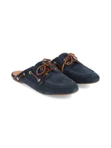 Zueco de cuero gamuza color azul marino, con diseño inspirado en los zapatos náuticos. Presenta cordones de cuero marrón, ojales metálicos dorados y costuras visibles en la puntera.