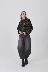 Campera de corderito con estampado animal print, de manga larga, cuello alto y cierre frontal completo.