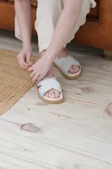 Sandalias planas color celeste y blanco, con tiras anchas cruzadas y suela color caramelo.