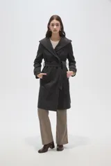 Tapado de paño color gris oscuro con solapas anchas, cierre frontal cruzado con botones y cinturón ajustable a la cintura. Posee mangas largas y bolsillos laterales.