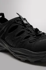 Sandalia deportiva negra con aberturas laterales para ventilación, puntera reforzada, ajuste con cordones y suela de goma.