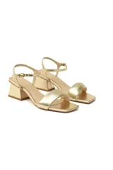Sandalias de cuero dorado metalizado con tira ancha delantera, pulsera delicada ajustable al tobillo y tacón bloque.