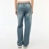 Pantalón de jean con corte baggy y pierna ancha, de tiro medio con cintura elástica ajustable mediante cordón. Presenta un lavado desgastado en tono azul medio.
