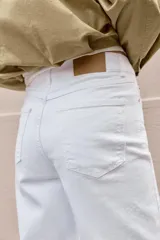 Jeans de tiro alto con diseño wide leg y corte cropped. Presenta cinco bolsillos, cierre frontal con cremallera y botón metálico.