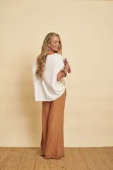 Blusa blanca de manga corta y corte holgado, con panel frontal de seda con estampado botánico y floral en tonos marrones y rojos.