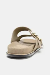 Sandalia plana color beige de serraje, con dos tiras anchas en el empeine ajustables con hebillas doradas y suela plana.