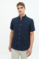 Camisa de manga corta confeccionada en una mezcla de lino y algodón, con cuello clásico, cierre frontal de botones y bolsillo en el pecho con logo bordado.