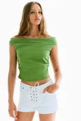 Top sin mangas color verde lima, con escote barco drapeado y frunces laterales que generan un efecto drapeado.