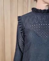 Polera de manga larga color blanco, confeccionada en algodón, con cuello alto tipo tortuga y detalles de volados en el cuello y en los puños.