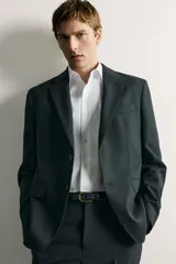 Camisa de corte regular fit color celeste, confeccionada en tejido fácil de planchar. Cuenta con cuello italiano abierto, manga larga con puño abotonado y cierre frontal con botonadura.