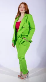 Blazer cruzado de color naranja vibrante, con solapas anchas y botones plateados. Presenta un cinturón a juego que ajusta la cintura y bolsillos frontales con solapa.
