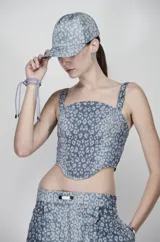Corset de denim con estampado de leopardo en tonos azules, corte ajustado y tirantes anchos.