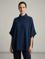 Capa tejida color fucsia, con cuello alto abotonado y mangas cortas estilo japonesa. Tejido de punto grueso.