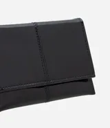 Billetera tipo sobre de tamaño pequeño, confeccionada en poliuretano con acabado barnizado brillante. Presenta un diseño minimalista con costuras verticales decorativas y cierre mediante botón a presión.