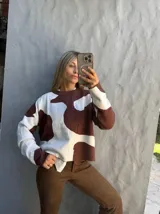 Sweater de punto con diseño de manchas abstractas en color marrón y blanco, de cuello redondo y manga larga.