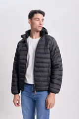 Campera negra capitoneada con capucha y cierre frontal.