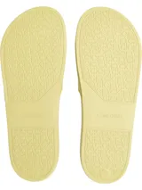 Ojotas tipo slide de Calvin Klein, color amarillo pálido. Presentan una suela moldeada ergonómica con soporte para el arco plantar y una capellada de doble tira de TPU con diseño en relieve y el logotipo de Calvin Klein grabado.