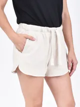 Short de algodón negro con cintura elástica, cordón ajustable y bolsillos laterales. Presenta un corte holgado con aberturas laterales redondeadas.