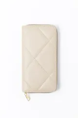 Billetera grande de color beige con diseño acolchado de costuras en forma de rombos y cierre perimetral con tirador metálico dorado.