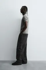 Camiseta gris de corte slim fit, confeccionada en tejido de algodón con elasticidad, cuello redondo y manga corta.