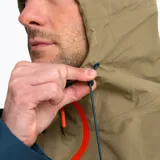 Campera impermeable tipo hardshell de la marca Merrell, con diseño bicolor en tonos arena y azul oscuro. Cuenta con capucha ajustable, cierre frontal y bolsillos en el pecho con cremalleras impermeables en color naranja vibrante, ventilación en axilas y puños ajustables.