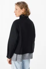 Chaqueta corta de paño color gris, con cuello alto, cierre frontal con cremallera y bolsillos delanteros con solapa.