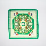 Pañuelo cuadrado de seda con estampado de motivos selváticos: hojas de palmera, flores exóticas, aves y tigres.