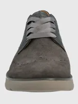 Sneaker de estilo oxford en tonos gris, confeccionada en gamuza con detalles perforados tipo brogue. Presenta cordones planos de cinta y una suela de plataforma en color gris claro.
