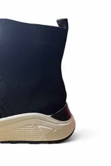 Bota deportiva Paddock Knicks tipo botineta tejida estilo media, color negro con suela blanca estructurada.