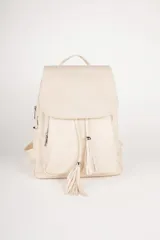 Mochila color beige de símil cuero con solapa frontal y cierre de cordón ajustable. Presenta dos flecos decorativos con cuentas plateadas en la parte delantera. Tiene un asa superior fija y dos correas regulables en la espalda. Incluye tres compartimentos principales, bolsillos internos adicionales y bolsillos laterales y traseros con cierre.
