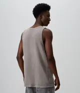 Musculosa de algodón con textura waffle, color gris topo, con corte sin mangas y detalles desgastados en los bordes. Cuenta con un estampado frontal localizado con la inscripción "Disobey".
