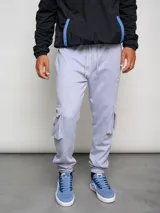 Pantalón cargo gris melange de algodón, poliéster y elastano, con bolsillos laterales tipo parche en las piernas y puños ajustados en los tobillos.