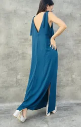 Vestido largo color verde azulado, con breteles finos que se atan en los hombros, escote en V en la espalda y tajo lateral.