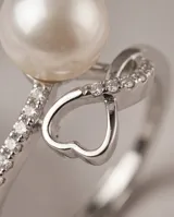 Anillo de plata 925 con diseño abierto, presenta una perla central y un detalle de corazón con circonias incrustadas.