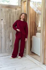Conjunto de dos piezas color tostado, compuesto por un buzo de cuello redondo con mangas largas y hombros caídos, y un pantalón de corte recto con cintura elástica y cordón ajustable.