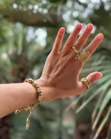 Pulsera artesanal compuesta por una serie de cuentas metálicas irregulares ensartadas en un hilo de algodón natural. Diseño rústico y minimalista.