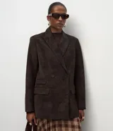 Blazer cruzado de gamuza sintética color marrón oscuro, con solapas de muesca, bolsillos con solapa y cierre de doble botonadura.