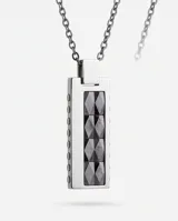 Collar de cadena de eslabones oscuros con dije rectangular de acero y detalles en cerámica con textura geométrica.