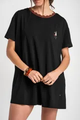 Vestido midi negro de algodón con mangas cortas, cuello redondo marrón con borde festoneado y pequeño bordado de velero en el pecho.