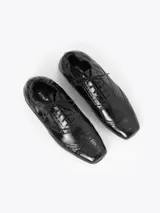 Zapato de cuero vacuno color blanco con acabado arrugado, diseño estilo oxford con detalles perforados, cordones y tacón bajo decorado con pedrería.