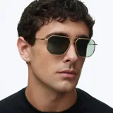 Lentes de sol con montura metálica dorada de diseño geométrico inspirado en el estilo aviador, con lentes polarizadas en color verde oliva.