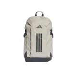 Mochila Adidas Primelift de color beige con detalles en gris oscuro, incluyendo correas de compresión laterales y refuerzo en la base. Presenta el logo de la marca y las icónicas tres tiras estampadas en la parte frontal.